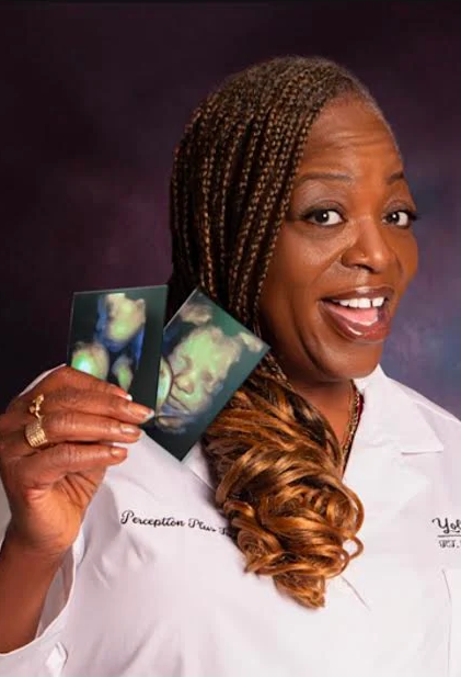 Yolanda, who runs Perception Plus Imaging, holding two 4D scan prints in her studio coat.