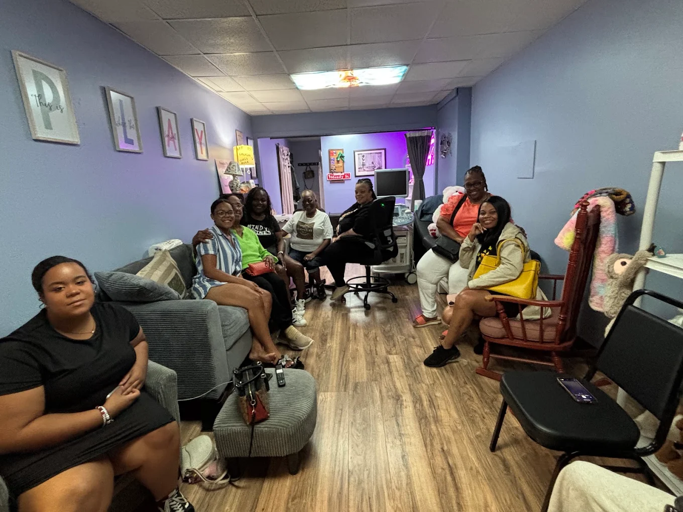 Family and friends filling the studio lounge, watching a scan together on the wall screen.